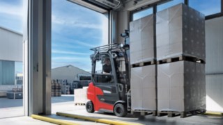 Der E-Stapler Xi20 PH von Linde Material Handling transportiert Waren aus dem Lager nach draußen.